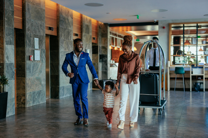 Family going to new hotel room with luggage.