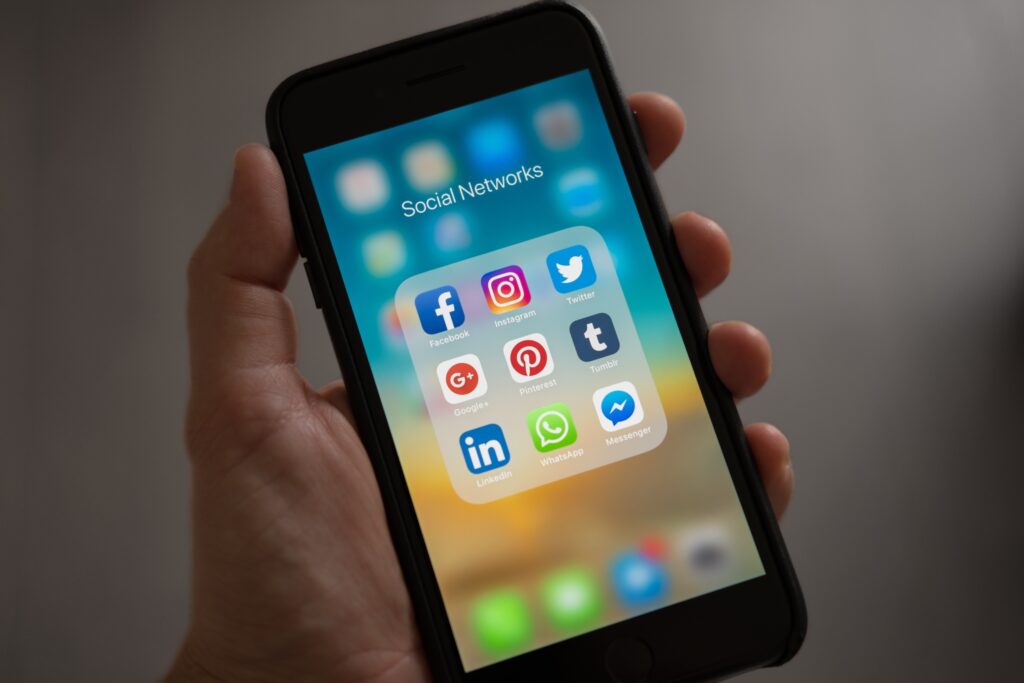 phone in hand showcasing social media apps folder
