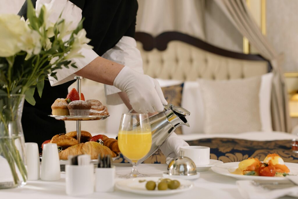Close up photo of a room service tray with orange juice and hot coffee - one of the reasons some may choose a hotel vs Airbnb.